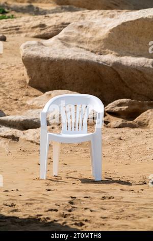 Einsamer Stuhl in der sandigen felsigen Wüste Stockfoto