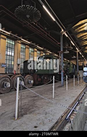 Eine Dampflokomotive und eine Diesellokomotive befinden sich im Depot zur Wartung in einem Museum Stockfoto