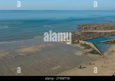 Plage du Plat Gousset, ein Sandstrand in Granville, Normandie, Frankreich, mit Meerwasser-Swimmingpool auf der rechten Seite. Stockfoto