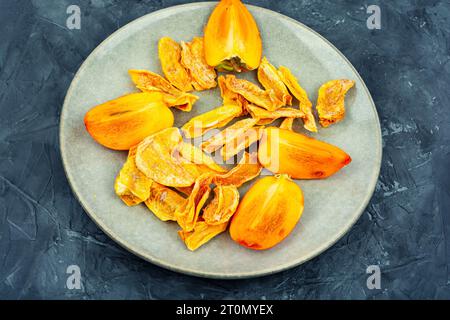 Süße getrocknete Persimone auf dem Teller. Gesunde vegane Snacks Stockfoto