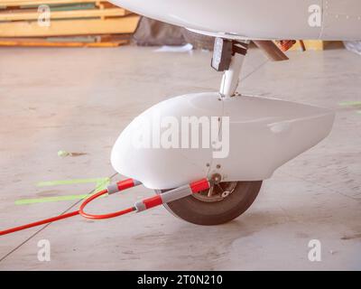 Details des ultraleichten Flugzeugrads im Hangar. Nahaufnahme des Flugzeugrads am Hangar Stockfoto