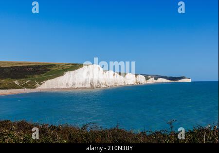 Panoramablick auf die Kreidefelsen der Sieben Sisters über Cuckmere Haven vom Seaford Head Nature Reserve in East Sussex aus an einem klaren, sonnigen Tag Stockfoto