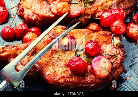 Zwei gekochte Steaks in einer Kirschmarinade. Gegrilltes Fleisch mit Beerensauce. Schließen Stockfoto