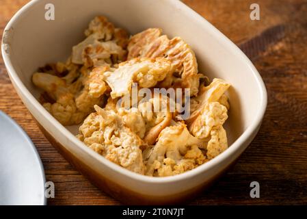 Frittierter Blumenkohl auf einem Teller auf hölzernem Hintergrund. Vegetarische Speisen Stockfoto