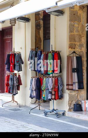 Schals hängen an einem zweilagigen runden Kleiderständer, ausgestellt in den Geschäften der Altstadt von Rhodos Stockfoto