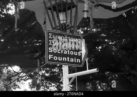 Schwarz-weißes Richtungsschild zum Brunnen Socratous (Castellania-Brunnen) an der besten Lage des Ippokratous-Platzes in Rhodos, Altstadt Stockfoto