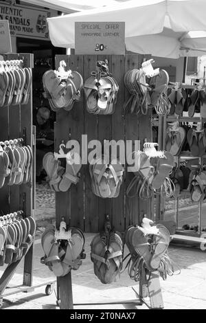 Handgefertigte Ledersandalen auf einem Holzregal zum Kauf in Rhodos City, Altstadt in Schwarz-weiß Stockfoto
