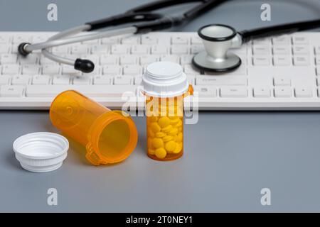 Verschreibungspflichtige Medikamente und Medikamentenflaschen mit Computertastatur. Gesundheitswesen, Telemedizin und Online-Apotheke Konzept. Stockfoto