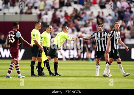 Schiedsrichter Peter Bankes schüttelt am Ende der ersten Halbzeit während des Premier League-Spiels im London Stadium die Hände mit den Spielern von Newcastle United. Bilddatum: Sonntag, 8. Oktober 2023. Stockfoto