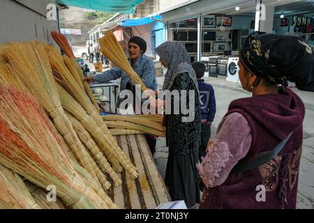 OSH, Kirgisistan - 8. Oktober 2023: Eine Frau, die Besen auf dem Jayma-Basar in Osh, Kirgisistan verkauft. Stockfoto