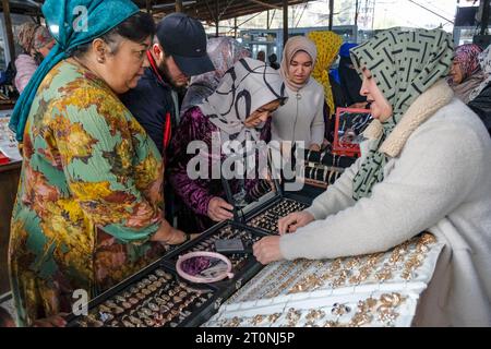 OSH, Kirgisistan - 8. Oktober 2023: Eine Frau, die Schmuck auf dem Jayma Basar in Osh, Kirgisistan verkauft. Stockfoto