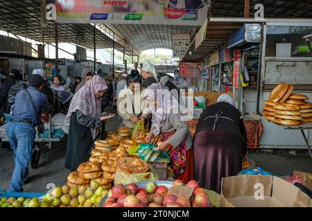 OSH, Kirgisistan - 8. Oktober 2023: Eine Frau, die Brot auf dem Jayma-Basar in Osh, Kirgisistan verkauft. Stockfoto