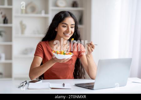 Fröhliche Millennials-hindu-Frau macht Mittagspause im Home Office Stockfoto