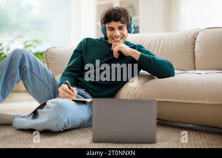 Junger arabischer Student, der Online-Unterricht über Laptop-Indoor ansieht Stockfoto
