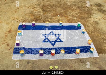 Trauerkerzen brennen auf dem Hintergrund der israelischen Nationalflagge. Holocaust-Gedenktag. Das Konzept des Moments der Stille. Nahaufnahme, Kopierbereich. Stockfoto
