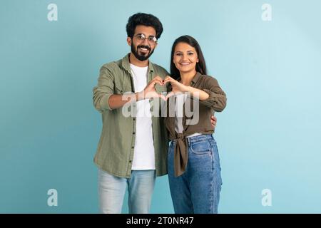 Fröhliche junge indianerin und arabischer Typ, der Herzgeste zeigt Stockfoto