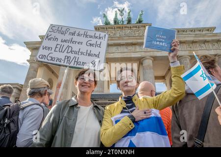 Berlin, Deutschland. Oktober 2023. Am 8. Oktober 2023 stand Saskia Esken, Parteivorsitzende der Sozialdemokratischen Partei Deutschlands, bei der Berliner Proteste solidarisch mit einem Demonstranten, der in eine israelische Flagge gehüllt war. Der Demonstrant hielt ein Schild mit der Aufschrift: "Ich stehe zu Israel." Vor dem Hintergrund des ikonischen Brandenburger Tores wurde ein weiterer Demonstrant mit einem Schild gesehen, auf dem stand: "Beenden Sie die Heuchelei, kein Geld mehr von der EU und Deutschland an Gaza, die Hamas." (Foto: Michael Kuenne/PRESSCOV/SIPA USA) Credit: SIPA USA/Alamy Live News Stockfoto