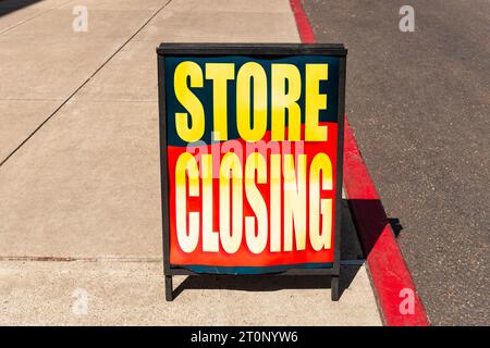 Ladenschließschild auf dem Bürgersteig vor einem Geschäft, das aus dem Geschäft geht. Stockfoto