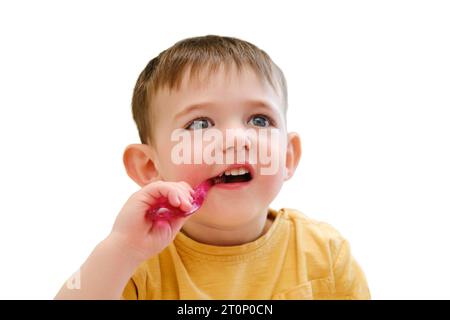 Ein Kind putzt sich die Zähne vor dem Schlafengehen in Sicherheit seines Kinderbetts, isoliert auf weißem Hintergrund. Kind im Alter von etwa zwei Jahren (ein Jahr elf Monate) Stockfoto