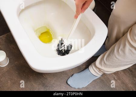 Frau, die Toilettenschüssel mit Bürste putzt, Nahansicht. Reinigungsservice Stockfoto