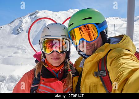 Skifahrerpaar machen ein Selfie-Foto im Skigebiet Tignes-Val d'Isere, Frankreich, während sie Helme und Spiegelbrille tragen. Aktiv, Tourismus. Stockfoto