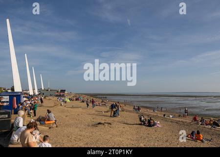 Southend on Sea, Großbritannien. Oktober 2023. Die Menschen entspannen und spielen an einem warmen Tag an der Sandküste von Southend-on-Sea. Der Strand ist voll mit Familien, Spaziergängern und Sonnenanbetern. Hohe weiße vertikale Strukturen und nahe gelegene Kioske bieten moderne architektonische Kontraste und Annehmlichkeiten. Bei Temperaturen über 25 °C gehen viele Leute an die Küste und die Strände in Southend. Penelope Barritt/Alamy Live News Stockfoto