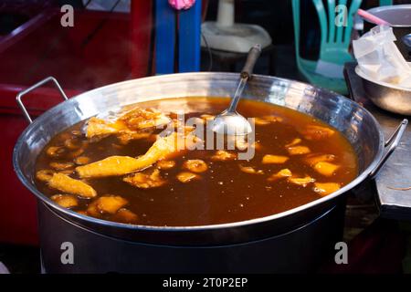 Geschmorte Fischsuppe in roter Soße oder Kra Poh Pla in großer Pfanne für thailänder Essen Sie Getränke in der Kathin Zeremonie und dem jährlichen Event Festival des Wat Phai Luean Stockfoto