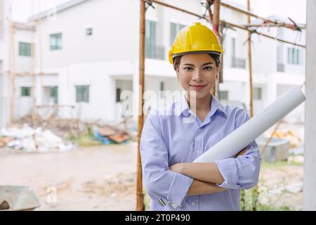 Kluge Frau Ingenieur Bauarbeiter auf der Baustelle. Architect HOME Project Chief Designer Officer mit Gebäudegrundriss. Stockfoto