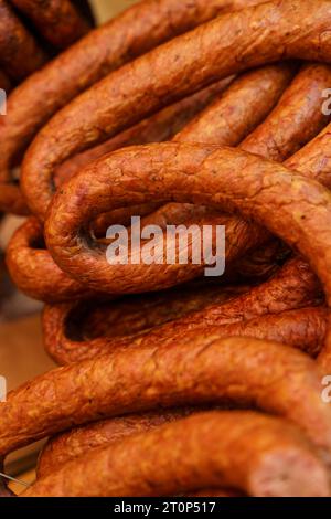 Es gibt rohe Räucherwürste auf dem Markt. Nahaufnahme. Vertikaler Rahmen. Stockfoto