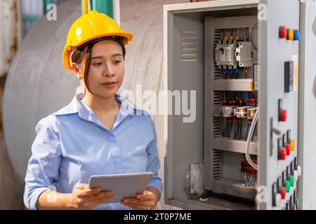 Elektriker Ingenieurin Frau Funktionsprüfung Wartung Elektrizität Hauptstromkreis Sicherung und Stromversorgungssystem in Industriewerk Stockfoto