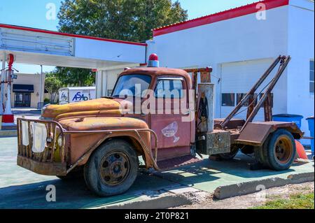 NEW ROADS, LA, USA - 19. SEPTEMBER 2023: Voller Blick auf einen verrosteten internationalen L-160-Abschleppwagen aus den 1950er Jahren vor einer Retro-Tankstelle Stockfoto