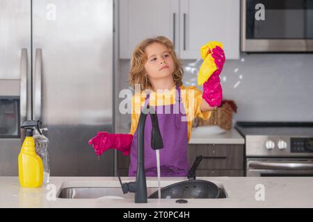 Wasch- und Reinigungskonzept. Kinder waschen und abwischen Geschirr in der Küche. Amerikanisches Kind lernt Hausarbeit zu Hause. Kinderreinigung, um Eltern zu helfen Stockfoto