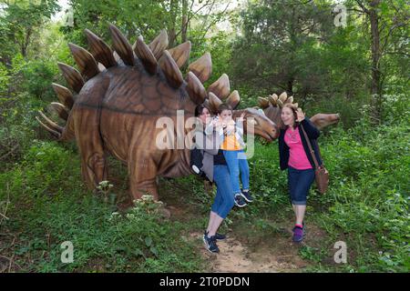 Kentucky USA 09-24-20 drei Besucher machen ein lustiges Foto vor einer Dinosauriernachbildung im Dinosaur World Park in der Stadt Cave City KY Stockfoto