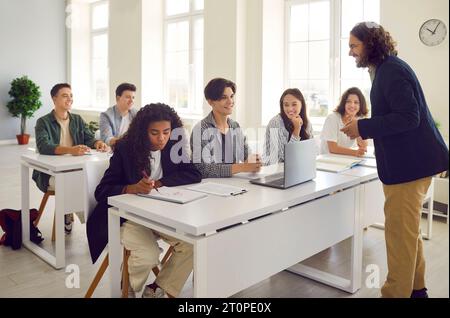 Der Lehrer führt Unterricht für Schüler der Oberstufe durch und diskutiert mit ihnen das Thema des Unterrichts. Stockfoto