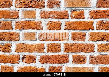 Alte verwitterte rote Ziegelwand als Hintergrund. Ziegelmauerwerk mit Nähten Stockfoto