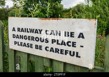 Schild Warnung Passagieren und Besuchern, vorsichtig zu sein in der Nähe von Gleisanlagen Stockfoto