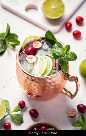 Weihnachten Moskau Mule Cocktail mit Cranberries und Limette in Kupferbechern zu Weihnachten Stockfoto