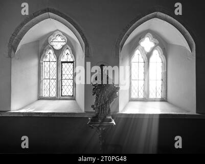 ST.HILARY KIRCHE SONNENLICHT STRÖMT DURCH DAS FENSTER UND BELEUCHTET DIE STATUE VON JESUS Stockfoto