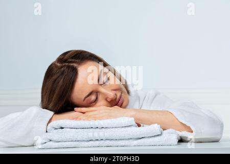 Schönheitsprofil einer Frau, die auf den Handtüchern im Bad schläft Stockfoto