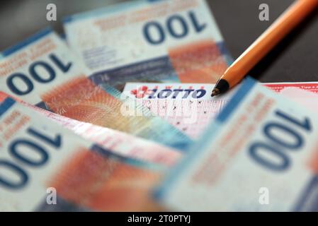 Lottoschein mit Geldnoten in Schweizer Franken SFr. Symbolbild. Lottoschein mit Geldnoten in Schweizer Franken SFr. Symbolbild. *** Lotterie-Ticket mit Geldscheinen in Schweizer Franken SFr Symbol-Lotterie-Ticket mit Geldscheinen in Schweizer Franken SFr Symbol-Credit: Imago/Alamy Live News Stockfoto