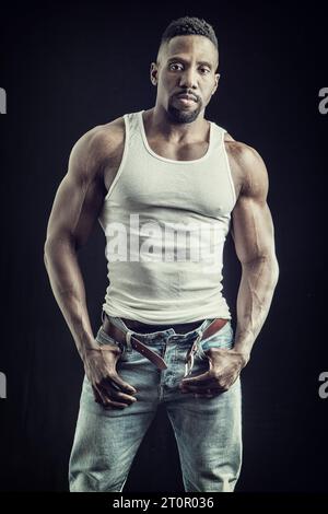 Ein Mann in Jeans und einem Tanktop posiert für ein Foto Stockfoto