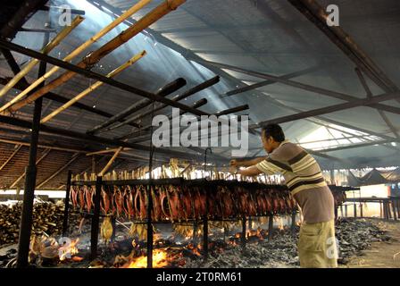 Blick auf eine Werkstatt zur Herstellung von geräuchertem Fisch, in der Bonito-Thunfischfleisch in einer Heimindustrie in Bitung, Nord-Sulawesi, Indonesien, verwendet wird. Der Beitrag indigener Wissens zur technologischen Innovation bietet laut dem Bericht des Zwischenstaatlichen Ausschusses für Klimaänderungen (IPCC) aus dem Jahr 2023 eine breite Palette von Optionen für das Management unter anderem der Ernährungssicherheit. Der im Volksmund als Cakalang Fufu bekannte geräucherte Thunfisch gilt als exotisches einheimisches Lebensmittel und könnte eine alternative Lösung für den Umgang mit den Auswirkungen des Klimawandels auf den Ozean werden. die Weltbank warnt, dass neben den Auswirkungen von... Stockfoto