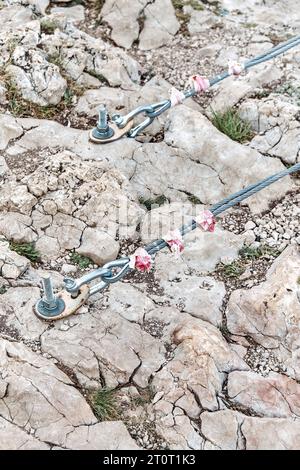 Befestigung von Hängebrücken in Fels mit großen Metallankern. Stützausrüstung in Steine eingeschraubt im Bergkletterpark Stockfoto