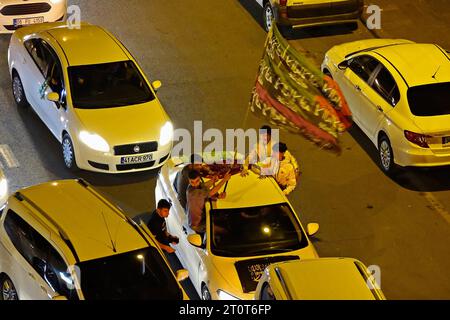 Junge Demonstranten sahen, wie sie eine Flagge mit islamischen Slogans und Symbolen in einem Auto schwenkten, die an einem Protest teilnahmen. Tausende von Menschen versammelten sich nachts mit Autos in Diyarbakir, wo die größte kurdische Bevölkerung der Türkei lebt, besuchten die Stadt mit Hunderten von Autos und protestierten gegen Israel. Die Teilnehmer der Demonstration, die von der kurdischen extremistischen Partei der Islamischen Freien Ursache (HUDA-PAR) organisiert wurde, die die regierende Partei für Gerechtigkeit und Entwicklung (AKP) unterstützt, trugen palästinensische Fahnen und riefen Parolen gegen Israel. (Foto: Mehmet Masum Suer/SOPA Images/SIPA USA) Stockfoto