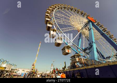 München, Deutschland, Europa - 16. September 2023. Gelände des Oktoberfest Beer Festivals mit Riesenrad, Fahrgeschäften im Vergnügungspark, Bierzelten und Biergärten. Stockfoto