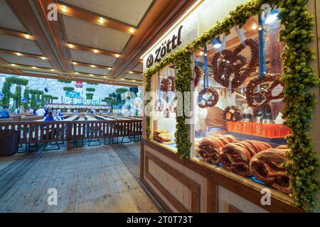 München, Deutschland, EU - 18. September 2023. Oktoberfest Münchner Hofbräu Bierhelzelt, Hofbräu-Festzelt Innenraum mit Zottl Bretzelshop Riesenbrezeln. Stockfoto