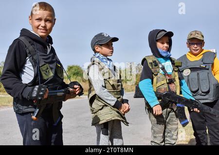 Bilenke, Ukraine. Oktober 2023. Kinder, die vorgeben, territoriale Verteidigungskämpfer zu sein, werden an ihrem Spielkontrollpunkt im Dorf Bilenke in der Region Zaporischschhia gesehen. Alle ukrainischen Kinder sind tief vom Krieg betroffen. Viele haben ihr Leben radikal verändert, weil sie ihre Häuser verloren haben oder gezwungen wurden, zu evakuieren. Quelle: SOPA Images Limited/Alamy Live News Stockfoto