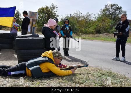 Bilenke, Ukraine. Oktober 2023. Kinder, die vorgeben, territoriale Verteidigungskämpfer zu sein, werden an ihrem Spielkontrollpunkt im Dorf Bilenke in der Region Zaporischschhia gesehen. Alle ukrainischen Kinder sind tief vom Krieg betroffen. Viele haben ihr Leben radikal verändert, weil sie ihre Häuser verloren haben oder gezwungen wurden, zu evakuieren. Quelle: SOPA Images Limited/Alamy Live News Stockfoto