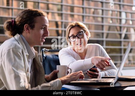 Frau und Mann arbeiten zusammen mit einem Laptop Stockfoto