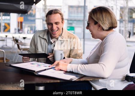 Frau und Mann arbeiten zusammen, während sie Kaffee trinken Stockfoto